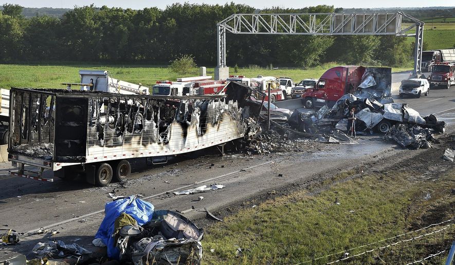 Investigators survey the scene of a multi-vehicle accident that claimed multiple lives on Tuesday, July 11, 2017, on westbound Interstate 70 just west of Bonner Springs, Kans. The crash closed the highway in both directions for about two hours. (Keith Myers/The Kansas City Star via AP)