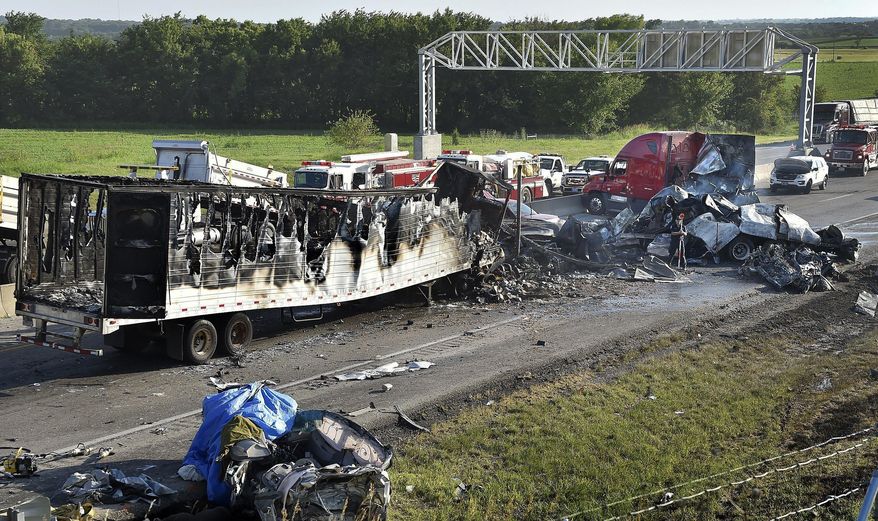 Investigators survey the scene of a multi-vehicle accident that claimed multiple lives on Tuesday, July 11, 2017, on westbound Interstate 70 just west of Bonner Springs, Kans. The crash closed the highway in both directions for about two hours. (Keith Myers/The Kansas City Star via AP)