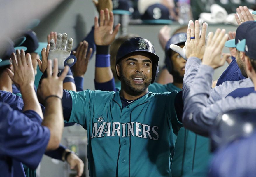 FILE - In this July 7, 2017, file photo, Seattle Mariners&#x27; Nelson Cruz is greeted in the dugout after he hit a three-run home run during the eighth inning of the team&#x27;s baseball game against the Oakland Athletics, in Seattle. Cruz is leading the American League in RBIs with 70 at the break despite playing through leg injuries during big chunks of the first half. (AP Photo/Ted S. Warren, File)