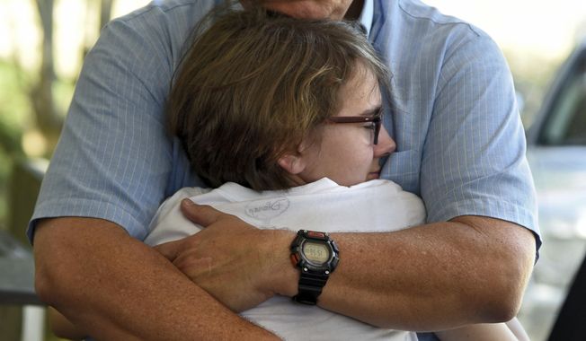 Terry Murray hugs his daughter Grace, 18, after speaking on behalf of his family about the loss of his son, Marines Sgt. Joseph Murray, at a press conference in Jacksonville, Fla., Wednesday, July 12, 2017. Sgt. Murray was one of the Marines killed in a plane crash Monday in Mississippi. (Bob Mack/The Florida Times-Union via AP)