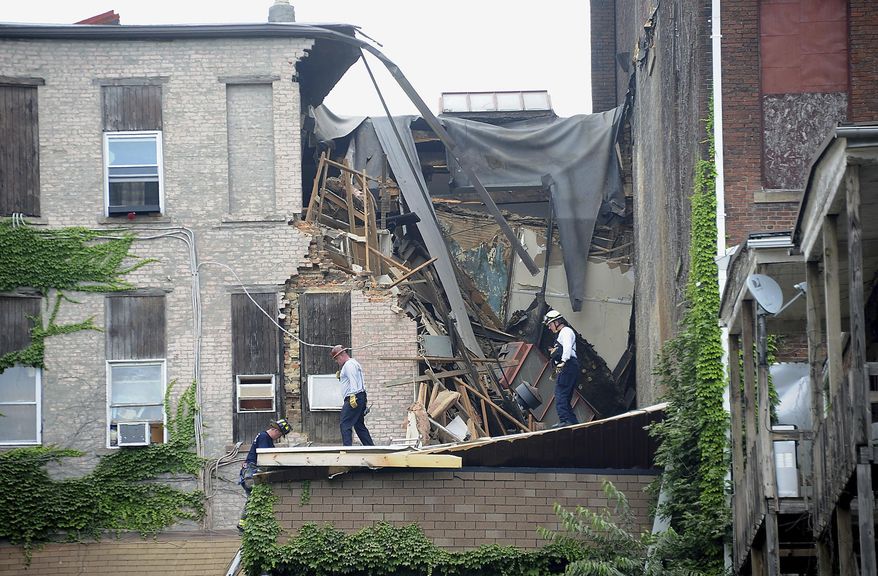 Emergency workers examine an apartment building that collapsed in Washington, Pa., Wednesday July 12, 2017. (Nate Guidry/Pittsburgh Post-Gazette via AP)