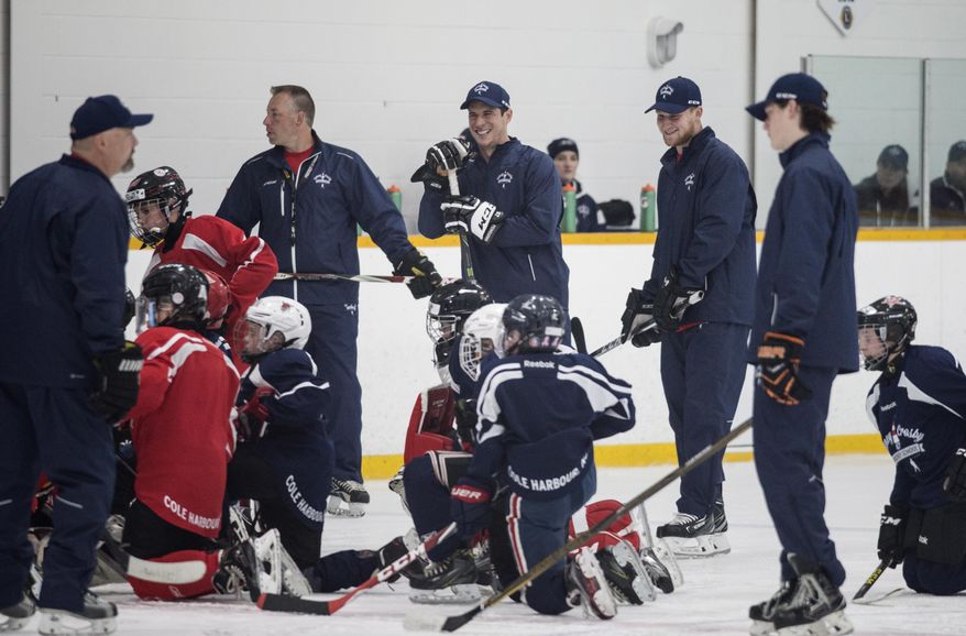 Pittsburgh Penguins NHL hockey player Sidney Crosby, center, laughs with Colorado Avalanche's Nathan MacKinnon, second from right, during an on-ice session at the Sidney Crosby Hockey School in Halifax, Nova Scotia, Wednesday, July 12, 2017. (Darren Calabrese/The Canadian Press via AP)