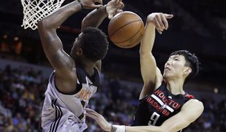 FILE - In this Monday, July 10, 2017, file photo, Houston Rockets&#x27; Zhou Qi, right, of China, fouls Phoenix Suns&#x27; Marquese Chriss during the second half of an NBA summer league basketball game in Las Vegas. When the Rockets signed Zhou and the Dallas Mavericks brought in Ding Yanyuhang to play on their summer league teams, there was some cynicism the moves were purely financially motivated for teams to tap more directly into the lucrative Chinese market. But little by little both are playing like they belong at the NBA&#x27;s summer league. (AP Photo/John Locher, File)
