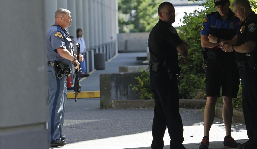 A Washington State Patrol trooper holds a gun after a lockdown at the state Capitol campus in Olympia, Wash. was lifted, Wednesday, July 12, 2017. The Patrol said in an email alert that troopers conducted a thorough search of buildings on campus Wednesday after reports of suspicious noises, but that nothing was found. (AP Photo/Ted S. Warren)