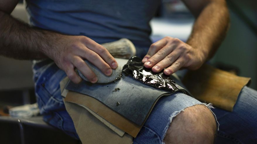 In this June 1, 2017, photo, Metin Eren, an archaeologist at Kent State University, flakes obsidian in Kent, Ohio. Eren runs a newly-opened laboratory which makes replicas of ancient arrows, knives, and pottery to be shot, crushed, and smashed. It's allowing researchers to learn about engineering techniques of the first native Americans without destroying priceless genuine relics in the process. (AP Photo/Dake Kang)