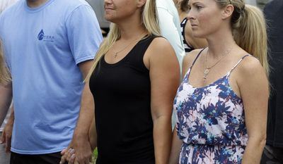 FILE - In a Wednesday, July 29, 2015 file photo, Carly Black, center, mother of Austin Stephanos, one of the missing teenage fishermen, listens as the U.S. Coast Guard makes a statement outside of the homes of the two teenagers missing since a fishing trip  July 24, in Tequesta, Fla.  U.S. District Judge William P. Dimitrouleas on Monday, July 10, 2017, lifted an injunction that kept Pamela and Philip Cohen from suing Carly Black in state court. She owned the 19-foot (6-meter) boat her son Austin Stephanos was in when he left Jupiter Inlet on July 24, 2015, with the Cohens' son Perry. (AP Photo/Lynne Sladky, File)
