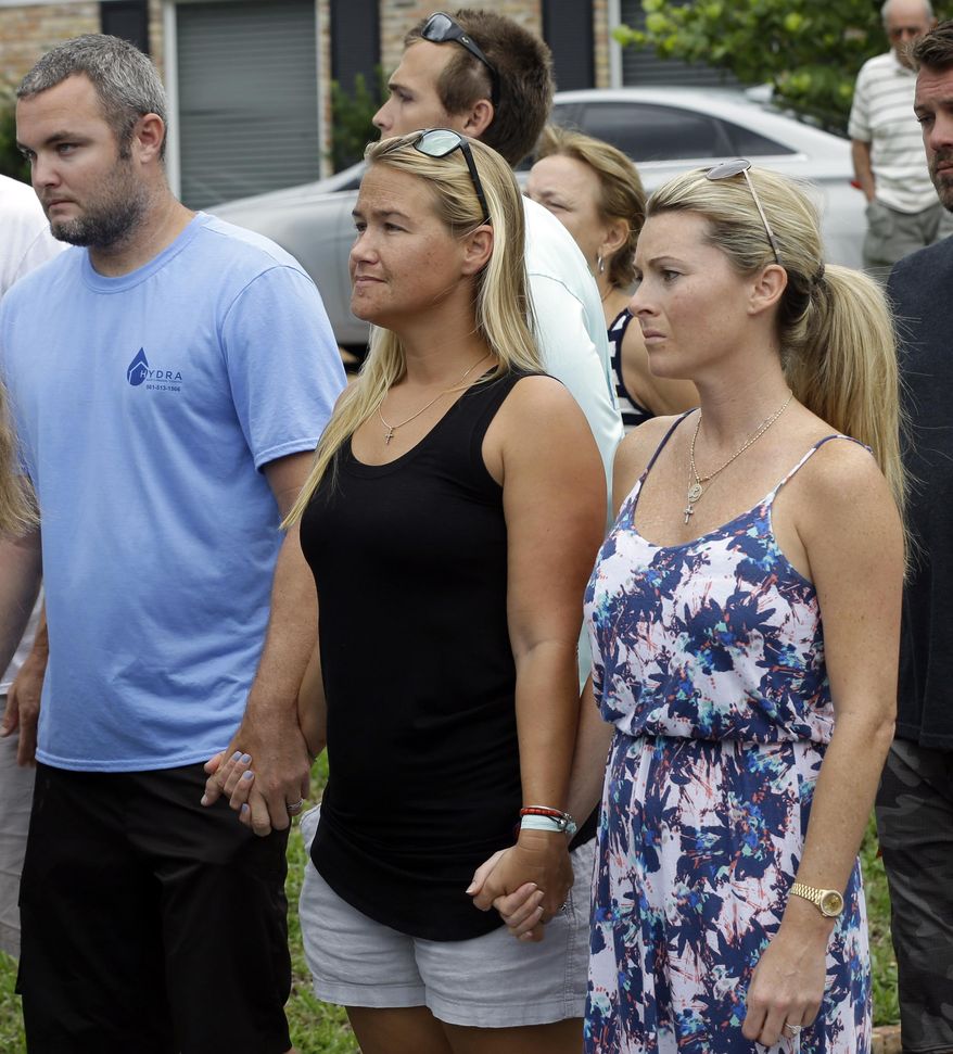 FILE - In a Wednesday, July 29, 2015 file photo, Carly Black, center, mother of Austin Stephanos, one of the missing teenage fishermen, listens as the U.S. Coast Guard makes a statement outside of the homes of the two teenagers missing since a fishing trip  July 24, in Tequesta, Fla.  U.S. District Judge William P. Dimitrouleas on Monday, July 10, 2017, lifted an injunction that kept Pamela and Philip Cohen from suing Carly Black in state court. She owned the 19-foot (6-meter) boat her son Austin Stephanos was in when he left Jupiter Inlet on July 24, 2015, with the Cohens' son Perry. (AP Photo/Lynne Sladky, File)