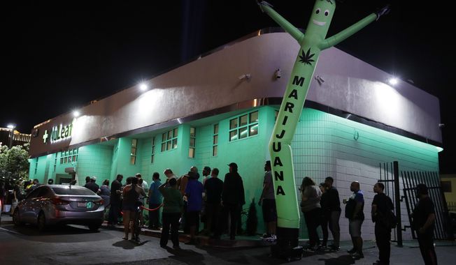 FILE- In this Saturday, July 1, 2017, file photo, people line up at the NuLeaf marijuana dispensary in Las Vegas. The Nevada Tax Commission is expected to approve an emergency regulation on Thursday, July 13, to issue distribution licenses needed to address an anticipated supply shortage in the coming weeks. (AP Photo/John Locher, File)