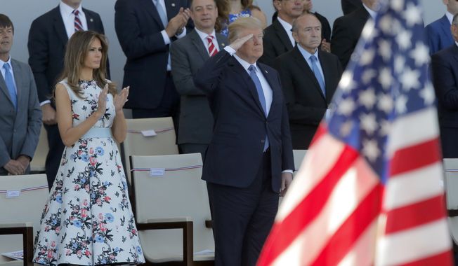 U.S. President Donald Trump salutes as he watches with his wife Melania Trump the traditional Bastille Day military parade on the Champs Elysees, in Paris, Friday, July 14, 2017. (AP Photo/Michel Euler) ** FILE **