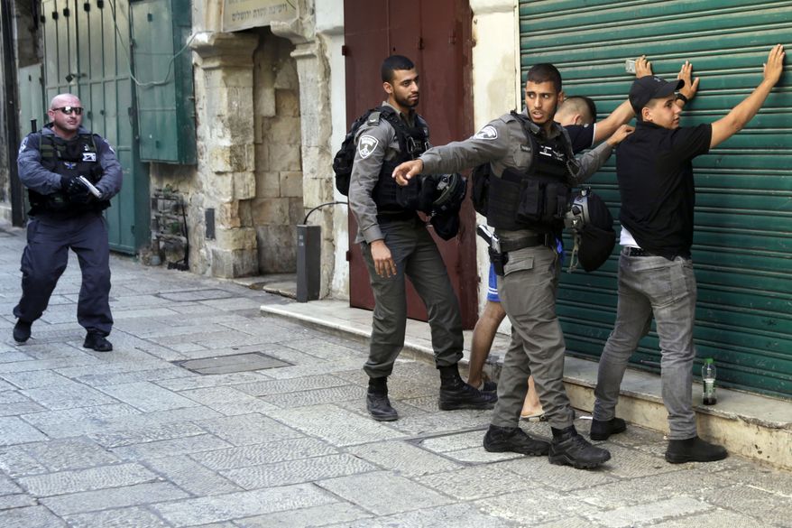 Israeli border police officers body-search Palestinians in Jerusalem's Old City, Friday, July 14, 2017. Three Palestinian assailants opened fire on Israeli police from inside a major Jerusalem holy site Friday, killing two officers before being shot dead, police said. (AP Photo/Mahmoud Illean)
