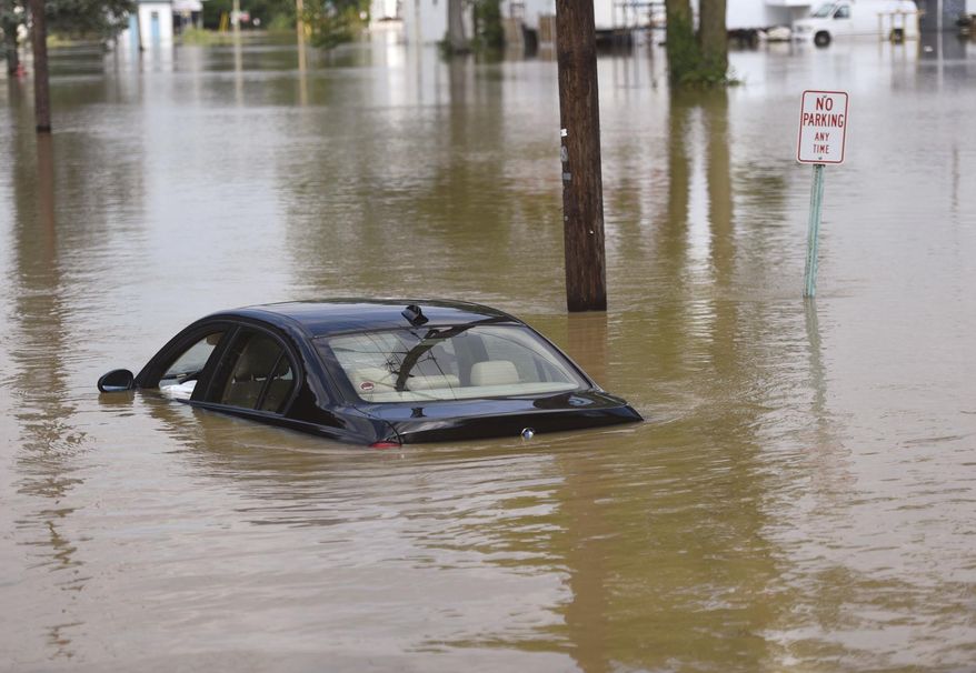 A BMW is stranded in floodwaters on Clinton Ct. in Findlay, Ohio, Friday, July 14, 2017. The Blanchard river was expected to crest Friday afternoon.(Randy Roberts/The Courier via AP)