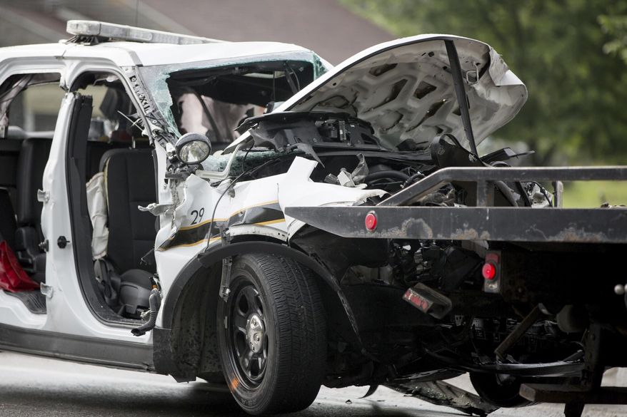 A Pennsylvania State Trooper vehicle is hooked up to a flat bed truck after a collision with a garbage truck in Ligonier Township, Pa., Friday, July 14, 2017. A state trooper died and another was injured in the crash. The conditions of the injured trooper and the garbage truck driver were not immediately known (Alex Driehaus//Pittsburgh Post-Gazette via AP)