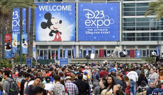 A crowd of people wait to enter the D23 Expo as crews do interviews outside the Anaheim Convention Center in Anaheim, Calif., on Friday, July 14, 2017. (Jeff Gritchen/The Orange County Register via AP)