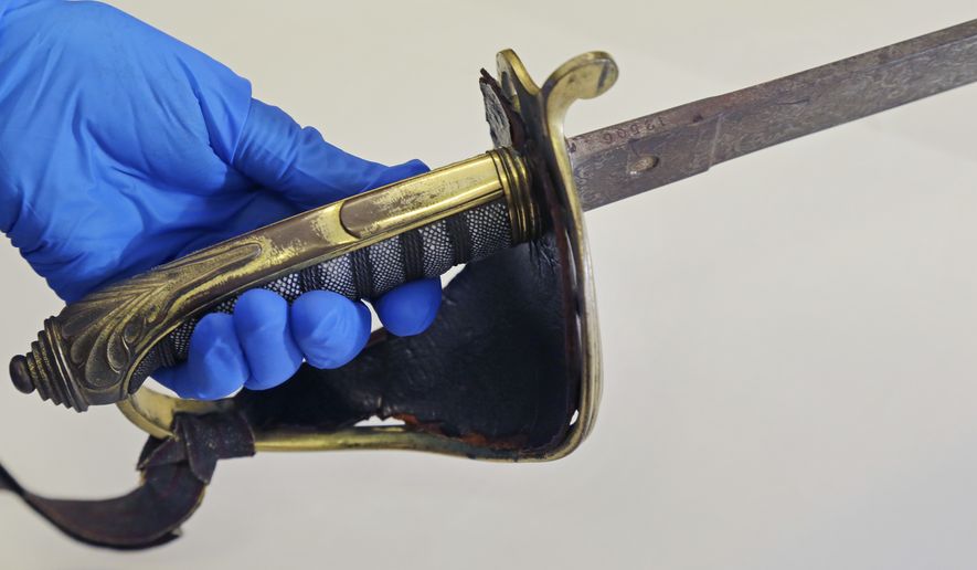 In this July 14, 2017 photo taken at the Massachusetts Historical Society in Boston, the sword that belonged to Col. Robert Gould Shaw, the commanding officer of the first all-black regiment raised in the North during the Civil War is held. The sword, stolen after Shaw was killed during the 54th Massachusetts Voluntary Infantry's attack on Fort Wagner, South Carolina in 1863, was recently found in the attic of a Boston-area home. (AP Photo/Elise Amendola)