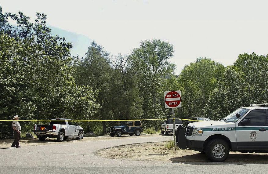 The Water Wheel Campground parking lot is blocked off by authorities Sunday, July 16, 2017, in the Tonto National Forest, Ariz., after a deadly flash-flooding hit Saturday afternoon at Cold Springs canyon. The flooding came after a severe thunderstorm pounded down on a nearby remote area that had been burned by a recent wildfire, Water Wheel Fire and Medical District Fire Chief Ron Sattelmaier said. (Alexis Bechman/Payson Roundup via AP)