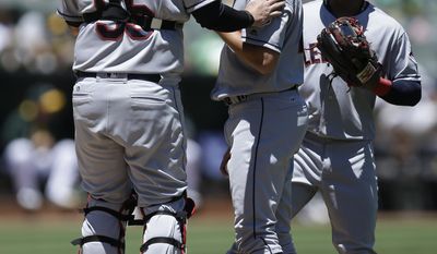 Cleveland Indians catcher Roberto Perez, left, speaks to pitcher Trevor Bauer, center, in the first inning of a baseball game against the Oakland Athletics, Sunday, July 16, 2017, in Oakland, Calif. (AP Photo/Ben Margot)