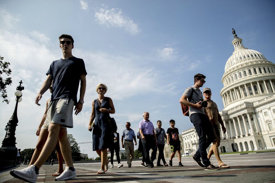 Tourists walks past the Capitol Building in Washington, Monday, July 17, 2017. The Senate has been forced to put the republican's health care bill on hold for as much as two weeks until Sen. John McCain, R-Ariz., can return from surgery. (AP Photo/Andrew Harnik)