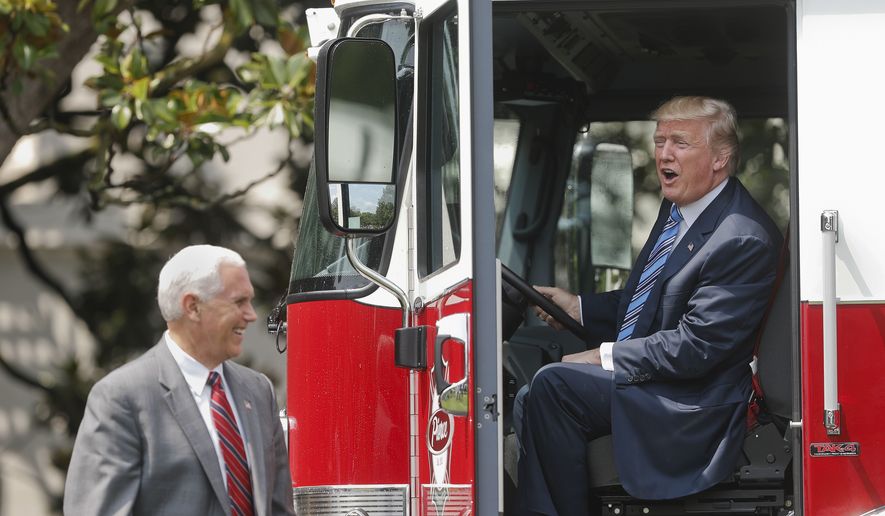 President Donald Trump, accompanied by Vice President Mike Pence, sits inside a cabin of a firetruck during a &quot;Made in America,&quot; product showcase featuring items created in each of the U.S. 50 states, Monday, July 17, 2017, on the South Lawn of the White House in Washington. (AP Photo/Pablo Martinez Monsivais)