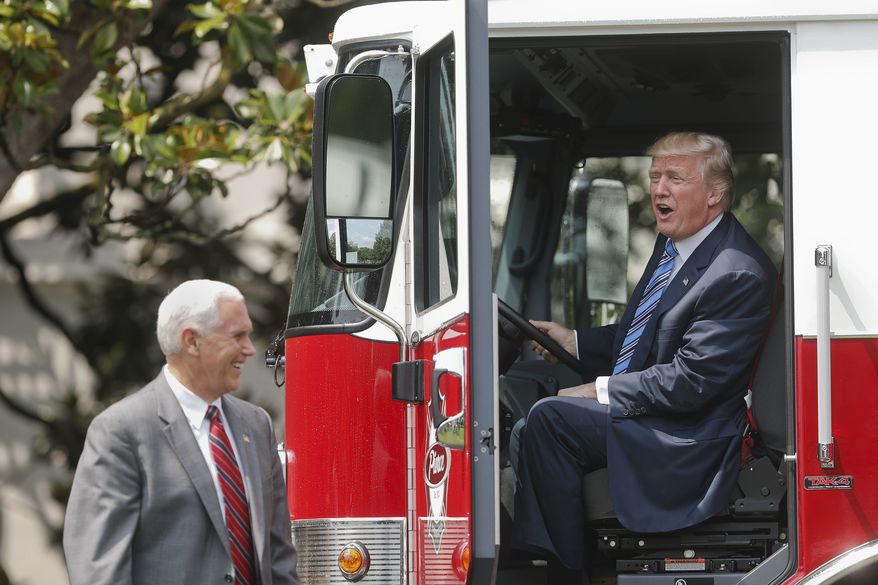 President Donald Trump, accompanied by Vice President Mike Pence, sits inside a cabin of a firetruck during a &quot;Made in America,&quot; product showcase featuring items created in each of the U.S. 50 states, Monday, July 17, 2017, on the South Lawn of the White House in Washington. (AP Photo/Pablo Martinez Monsivais)