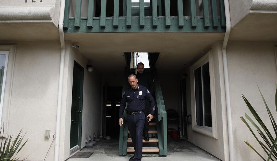 Seal Beach Police Chief Joe Miller leaves an apartment building after inspecting a crime scene, Monday, July 17, 2017, in Seal Beach, Calif. SWAT officers discovered two bodies when they entered the apartment after someone inside called for help and neighbors reported gunshots and screaming. (AP Photo/Jae C. Hong)