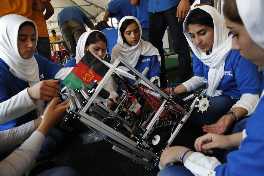 Lida Azizi, right, and other members of the Afghanistan team make a repair to their robot after their first round competing in the FIRST Global Robotics Challenge, Monday, July 17, 2017, in Washington. The challenge is an international robotics event with teams from over 100 countries. (AP Photo/Jacquelyn Martin)