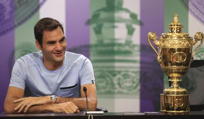 Switzerland&#x27;s Roger Federer speaks next to the Men&#x27;s Single&#x27;s tennis trophy he won on Sunday during a photo call at The All England Lawn Tennis and Croquet Club, Wimbledon, England, Monday July 17, 2017. Federer&#x27;s eighth Wimbledon title pushed him back up to No.3 in the ATP rankings. (Adam Davy/PA via AP)