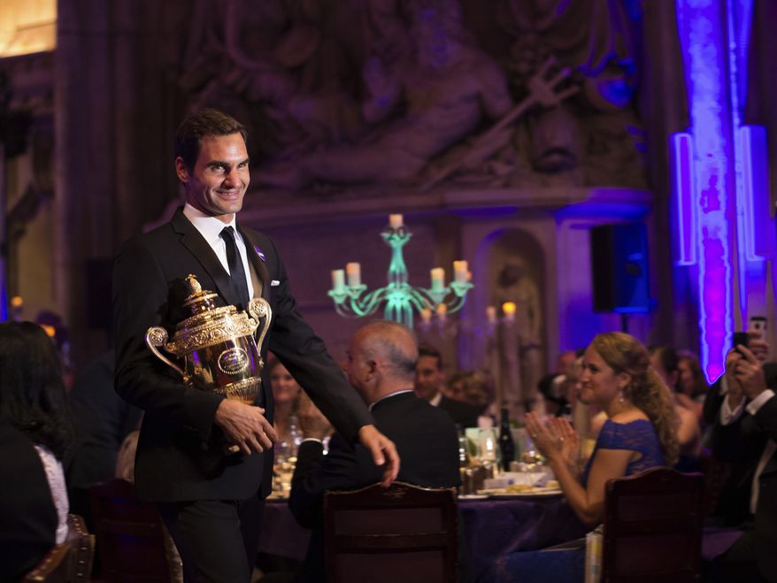 The 2017 Wimbledon Men's Singles champion Roger Federer of Switzerland arrives with his trophy for the Champions Dinner at The Guildhall in London, late Sunday July 16, 2017. (Jon Buckle/AELTC, Pool via AP)