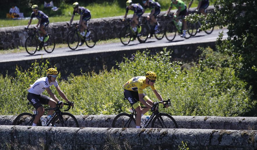 Britain's Chris Froome, wearing the overall leader's yellow jersey, and teammate Spain's Mikel Landa cross a bridge as the rest of the pack follows during the fifteenth stage of the Tour de France cycling race over 189.5 kilometers (117.8 miles) with start in Laissac-Severac l'Eglise and finish in Le Puy-en-Velay, France, Sunday, July 16, 2017. (AP Photo/Christophe Ena)