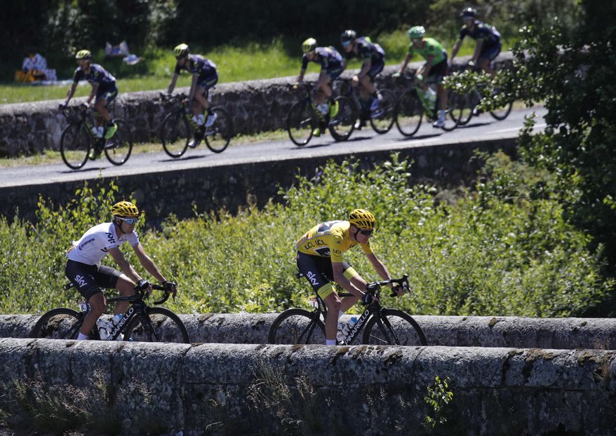 Britain's Chris Froome, wearing the overall leader's yellow jersey, and teammate Spain's Mikel Landa cross a bridge as the rest of the pack follows during the fifteenth stage of the Tour de France cycling race over 189.5 kilometers (117.8 miles) with start in Laissac-Severac l'Eglise and finish in Le Puy-en-Velay, France, Sunday, July 16, 2017. (AP Photo/Christophe Ena)