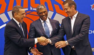 New York Knicks general manager Scott Perry, left, shakes hands with head coach Jeff Hornacek, right, while posing for a picture along with new president Steve Mills, during a news conference in in Greenburgh, N.Y., Monday, July 17, 2017. (AP Photo/Seth Wenig)