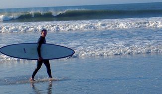 In this August 2010 photo provided by Harry Martin, then-U.S. Army Gen. Michael Flynn carries his surfboard on Sachuest Beach, in Middletown, R.I. The former National Security Adviser, at the center of multiple probes into Russia&#39;s interference in the 2016 presidential election, is seeking sanctuary from the swirling eddy of news coverage in the beach town where he grew up. (Harry Martin via AP)