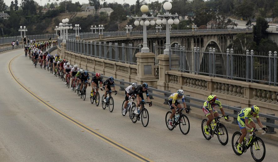 FILE - In this May 17, 2015, file photo, bicyclists cross the Colorado Street Bridge on the final stage of the Amgen Tour of California cycling in Pasadena, Calif. Citing an increase in suicide attempts, officials are installing temporary fencing on the famous Los Angeles-area bridge to prevent people from climbing over the side. The city council is expected to discuss a more permanent solution at a meeting Wednesday, July 19, 2017. (AP Photo/Damian Dovarganes, File)