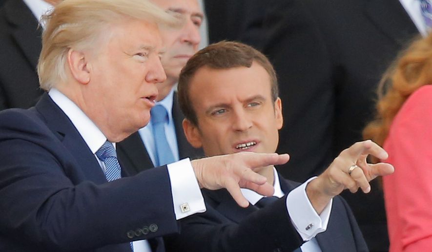 French President Emmanuel Macron (right) wants President Trump to reconsider exiting the Paris climate deal. Mr. Trump said he might if the deal is changed in U.S. favor, but European leaders say it is complete as written. (Associated Press)