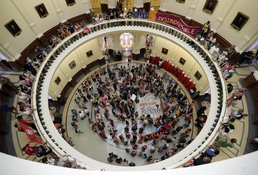 Protesters gather in the Texas Capitol Rotunda as State lawmakers begin a special legislative session called by Republican Gov. Greg Abbott in Austin, Texas, Tuesday, July 18, 2017. Immigrant rights groups plan to increase protests of the new law that allows police to inquire about peoples' immigration status, while LGBT activists bitterly oppose "bathroom bill" proposals. (AP Photo/Eric Gay)