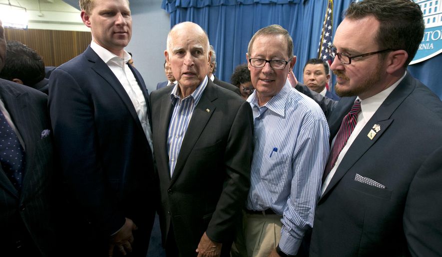 Gov. Jerry Brown, center left, flanked by Republicans, Assembly Leader Chad Mayes, of Yucca Valley, left, Tom Berryhill, center right, of Twain Harte, and Devon Mathis, of Visalia, right, leaves a news conference after the Legislature approved a pair of climate change bills, Monday, July 17, 2017, in Sacramento, Calif. Brown was able to get Republican support for the measure, which will extend the state's cap-and-trade program. (AP Photo/Rich Pedroncelli)