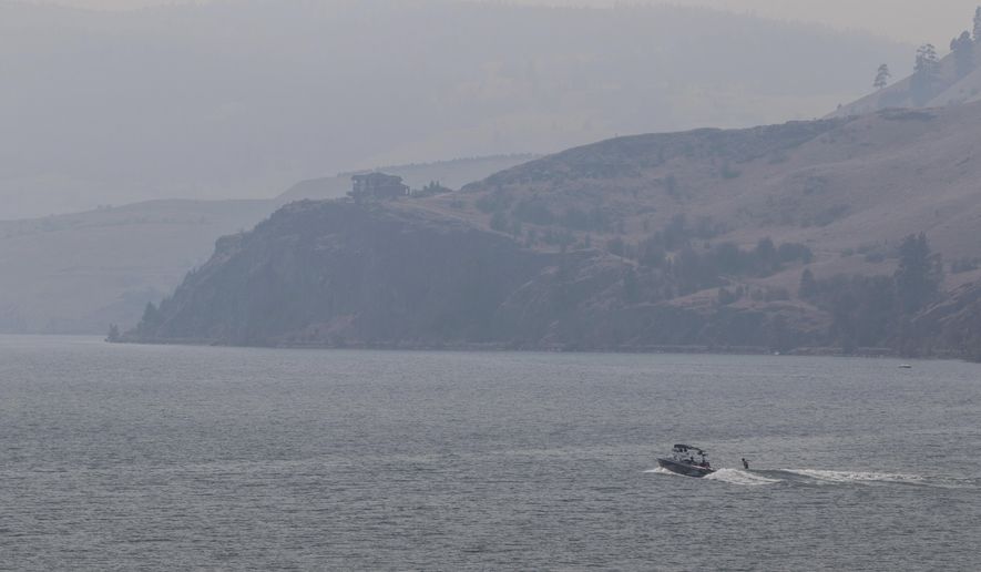 Smoke hangs over Lake Kalamalka in Vernon, British Columbia, Monday, July 17, 2017. The Okanagan area is blanketed with smoke from the wildfires burning in the interior of the province. (Jeff Bassett/The Canadian Press via AP)