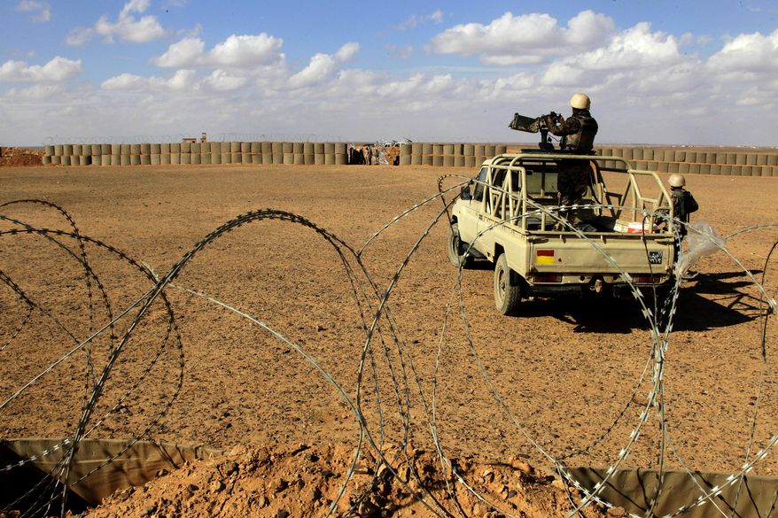 In this Feb. 14, 2017 file photo, Jordanian soldiers stand guard at the northeastern border with Syria, close to the informal Rukban camp for displaced Syrians. Desperate to help Syrians stuck on Jordan's sealed border, U.N. agencies reluctantly agreed late last year to hand much of the control over aid distribution to Jordan's military, a Jordanian contractor and a Syrian militia. Since then, the system has broken down repeatedly and only sporadic aid shipments have reached the two remote desert camps on the border. (AP Photo/Raad Adayleh, File)