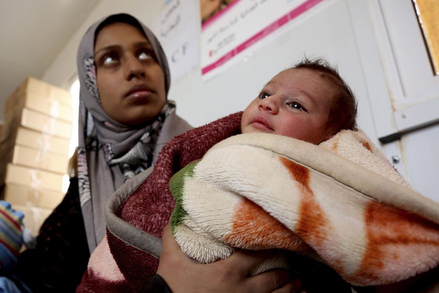 FILE - In this Feb. 14, 2017 file photo, a Syrian child from the informal Rukban camp for displaced Syrians, between the Jordan and Syria borders, receives treatment in a clinic run by UNICEF inside Jordan. Desperate to help Syrians stuck on Jordan's sealed border, U.N. agencies reluctantly agreed late last year to hand much of the control over aid distribution to Jordan's military, a Jordanian contractor and a Syrian militia. Since then, the system has broken down repeatedly and only sporadic aid shipments have reached the two remote desert camps on the border. (AP Photo/Raad Adayleh, File)