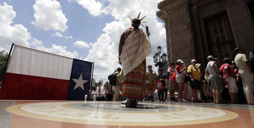 Peace Washington stands on the Texas seal as protesters enter the Texas Capitol while State lawmakers begin a special legislative session called by Republican Gov. Greg Abbott in Austin, Texas, Tuesday, July 18, 2017. Immigrant rights groups plan to increase protests of the new law that allows police to inquire about peoples' immigration status, while LGBT activists bitterly oppose "bathroom bill" proposals. (AP Photo/Eric Gay)