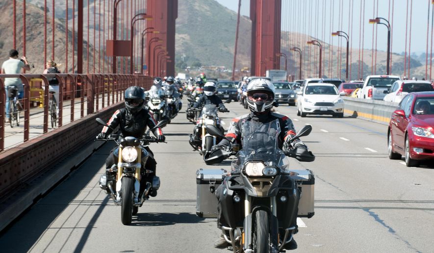 In this July 2016 photo provided by Alisa Clickenger, Clickenger leads a group of women riders over the Golden Gate Bridge in San Francisco at the end of a cross-country trip to honor two sisters from Brooklyn, N.Y., who made a similar ride in 1916. Clickenger operates Women's Motorcycle Tours, which conducts motorcycle rides that cater exclusively to women, and estimates she's traveled more than 250,000 miles on motorcycles. (Christina Shook/Courtesy of Alisa Clickenger via AP)