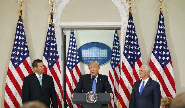 President Donald Trump, with Kansas Secretary of State Kris Kobach, left, and Vice President Mike Pence, right, speaks at a meeting of the Presidential Advisory Commission on Election Integrity, Wednesday, July 19, 2017, in the Eisenhower Executive Office Building on the White House complex in Washington. (AP Photo/Pablo Martinez Monsivais)