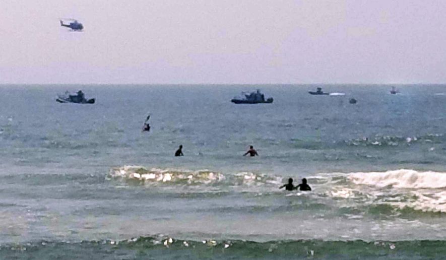 In this photo provided by ToniAnne Campasano Alvino, three rescue boats tow a helicopter that is almost entirely submerged, at far right, in the water off of Gilbo Beach, N.Y., on Long Island after the Robinson R 44 helicopter made an emergency ocean landing Wednesday, July 19, 2017. Shane McMahon, the son of World Wrestling Entertainment CEO Vince McMahon, was a passenger on the aircraft, and neither he, nor the pilot were hurt. The Federal Aviation Administration said the helicopter had taken off from Westchester County Airport in White Plains, N.Y. (ToniAnne Campasano Alvino via AP)