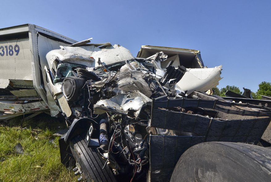 Debris after a deadly wreck is seen on the westbound Interstate 70 near Terre Haute, Ind., Tuesday, July 18, 2017. Indiana State Police say at least two young children have died and a third has been critically injured after a semitrailer struck their family's van on Interstate 70 in western Indiana. (Austen Leake/The Tribune-Star via AP)