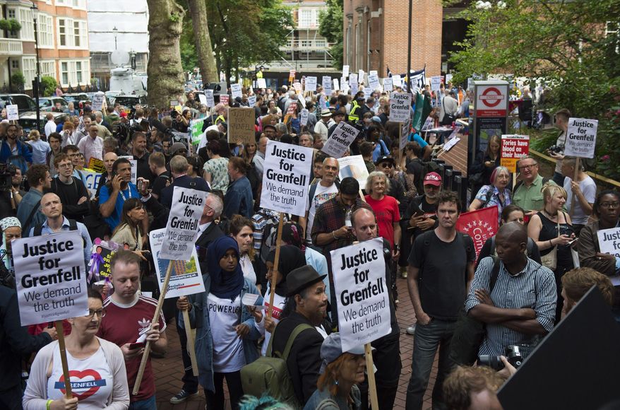 People protest ahead of a meeting of Kensington and Chelsea Council at Kensington Town Hall in west London, Wednesday July 19, 2017, the local authority in control of response to the recent Grenfell Tower fire. The fire at the Grenfell Tower residential bloc left dozens dead. (Ben Stevens/PA via AP)