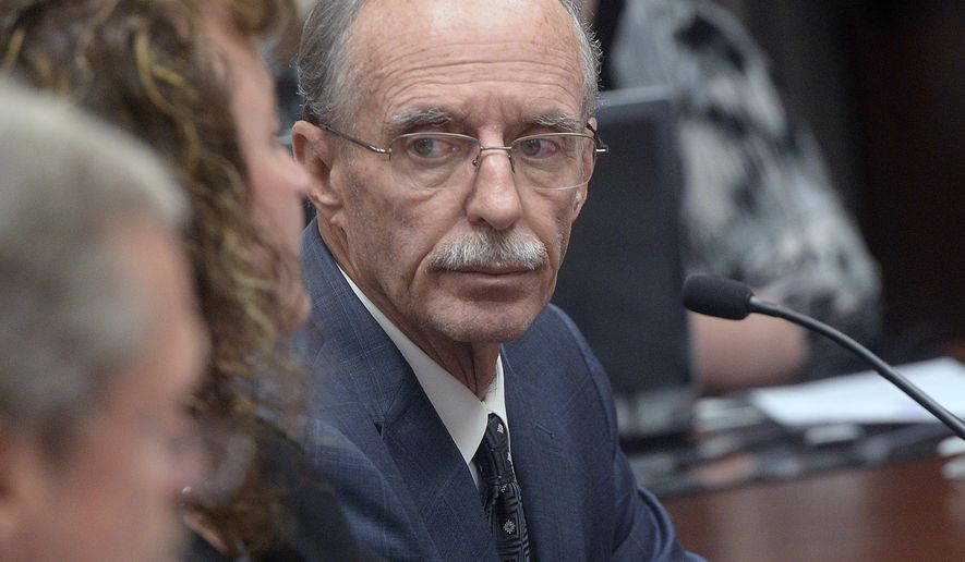 In this Oct. 4, 2016, photo, Salt Lake County County Recorder Gary Ott sits with his chief deputy Julie Dole before the Salt Lake County Council's presentation of findings of the county auditor's performance review in Salt Lake City. Salt Lake County District Attorney Sim Gill and Salt Lake County Mayor Ben McAdams said in a statement Thursday, July 20, 2017, that Ott, who has been placed under his family's guardianship after more than a year public questions about his mental capacity will resign his office, would resign his office Aug. 1. (Al Hartmann/The Salt Lake Tribune via AP)