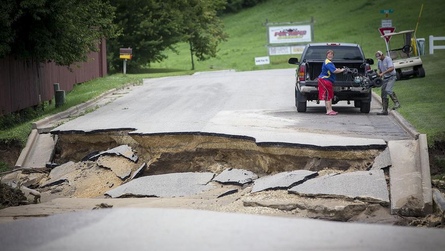 A road buckled after flooding, Thursday, July 20, 2017 in Arcadia, Wis. Much of the town was flooded after Wednesday night's rain flooding the Trempealeau River and Turton Creek. (Elizabeth Flores/Star Tribune via AP)