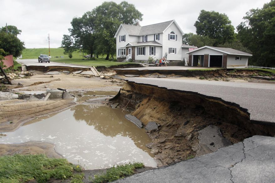 A section of North Oak Street is caved in and impassable Thursday, July 20, 2017, in Arcadia, Wis., following thunderstorms the night before that caused nearby Turton Creek to overflow its banks. Several hundred people evacuated their homes early Thursday in the small western Wisconsin community. (Chuck Miller/The Daily news via AP)