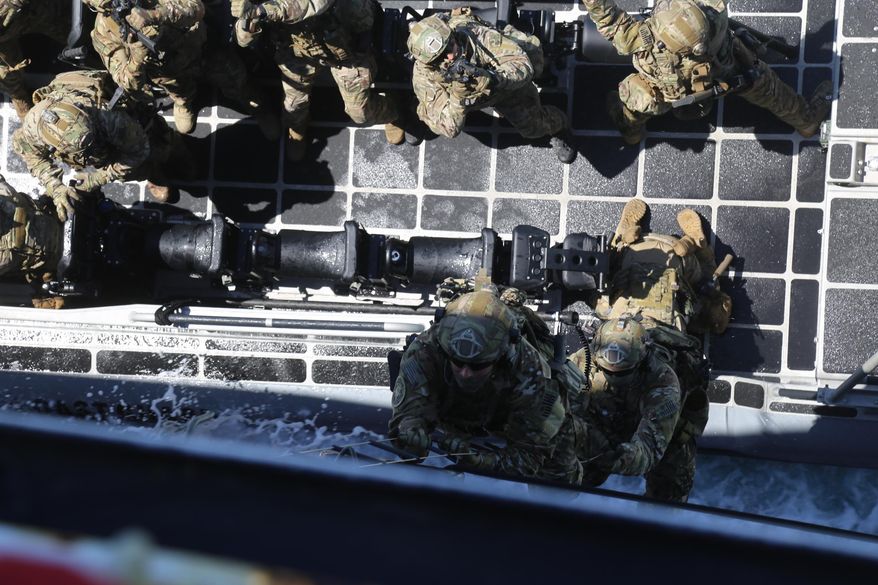 Members of the Coast Guard’s Maritime Safety and Security Team climb aboard the Coast Guard Cutter Aspen, off Long Beach, Calif., Thursday, July 20, 2017, as part of a training demonstration. (AP Photo/Mike Balsamo)