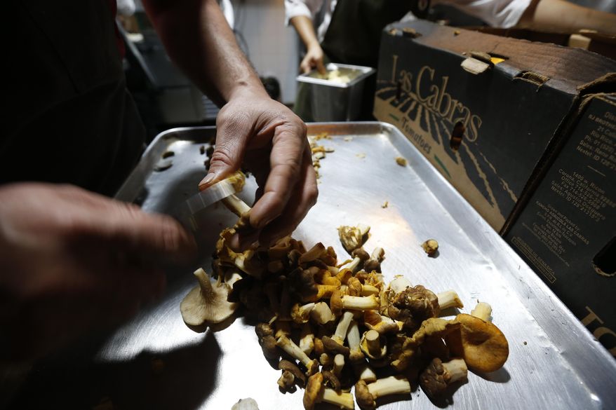 In this July 13, 2017 photo, chef Eduardo Garcia, founder of Maximo Bistrot and former migrant worker in the U.S., cuts mushrooms at his restaurant in Mexico City. Diners reserve weeks in advance for a coveted table at Maximo Bistrot, one of three restaurants Garcia runs. (AP Photo/Marco Ugarte)