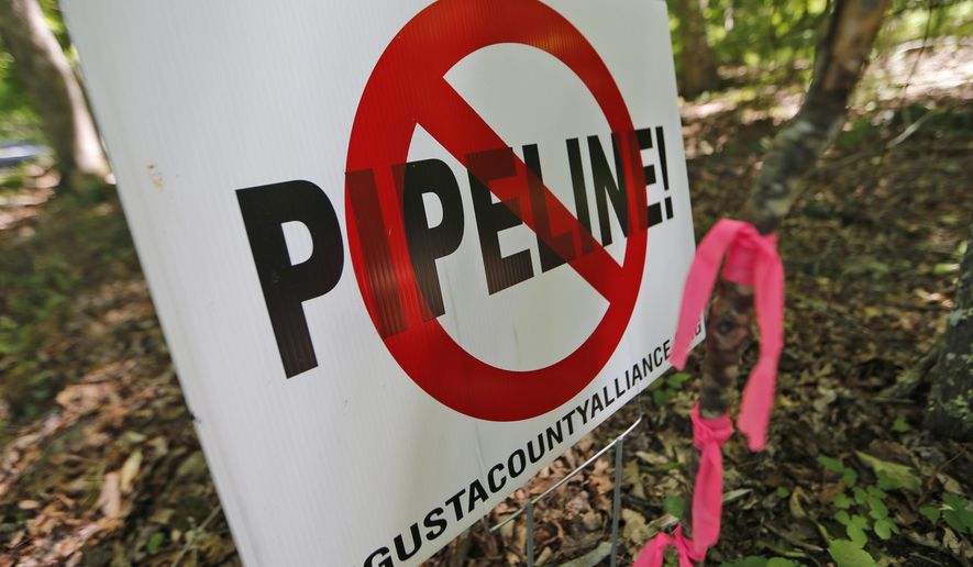 In this Tuesday June 6, 2017 file photo, a No Pipeline sign is posted next to a property line marker only a few feet from the center line of the route of the proposed Atlantic Coast Pipeline in Bolar, Va. The Federal Energy Regulatory Commission, which oversees interstate natural gas pipelines, released its final environmental impact statement Friday, July 21, 2017 for the proposed 600-mile (965-kilometer) pipeline, which has broad support from political and business leaders but is staunchly opposed by environmentalists and many affected landowners. (AP Photo/Steve Helber) **FILE**